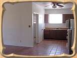 The kitchen wraps around into a spacious, tiled living room, and is adjacent to the master bedroom.